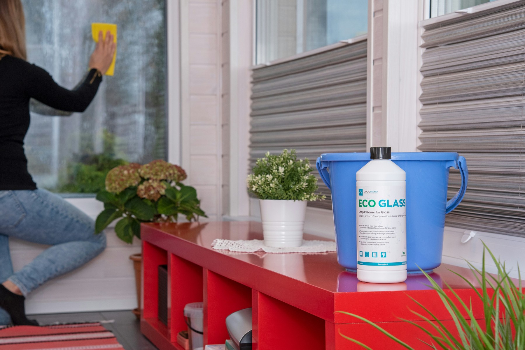 Glasreiniger wird auf eine Scheibe gesprüht mit sichtbaren Schlieren